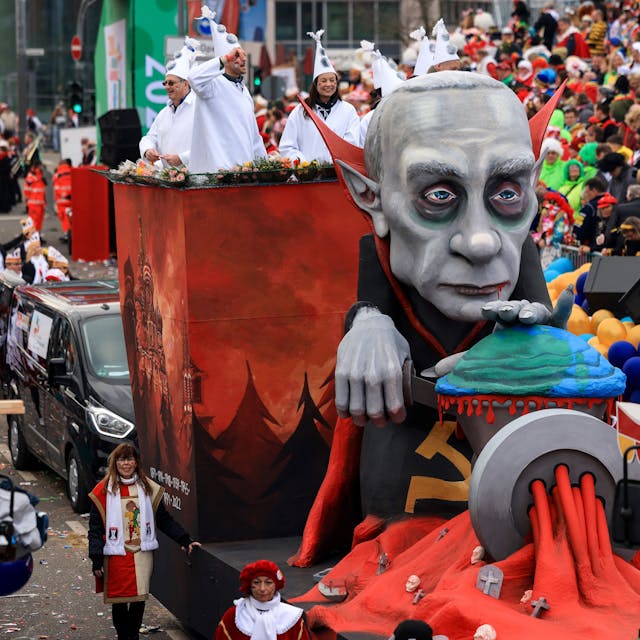 Der Mottowagen „1915-1926 1940-1948“ mit einer Darstellung des russischen Präsidenten Putin als Vampir Nosferatu, der die Welt durch einen Fleischwolf dreht, fährt im Festumzug mit.