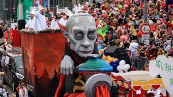 Der Mottowagen „1915-1926 1940-1948“ mit einer Darstellung des russischen Präsidenten Putin als Vampir Nosferatu, der die Welt durch einen Fleischwolf dreht, fährt im Festumzug mit.