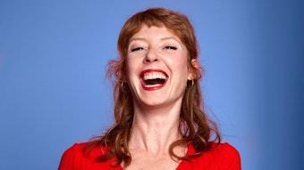 Schauspielerein Sarah Bauerett lacht in die Kamera.