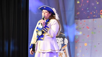 Monica Molitor auf einer Bühne im Kostüm der Blau-Wiesse Funke Wahn.