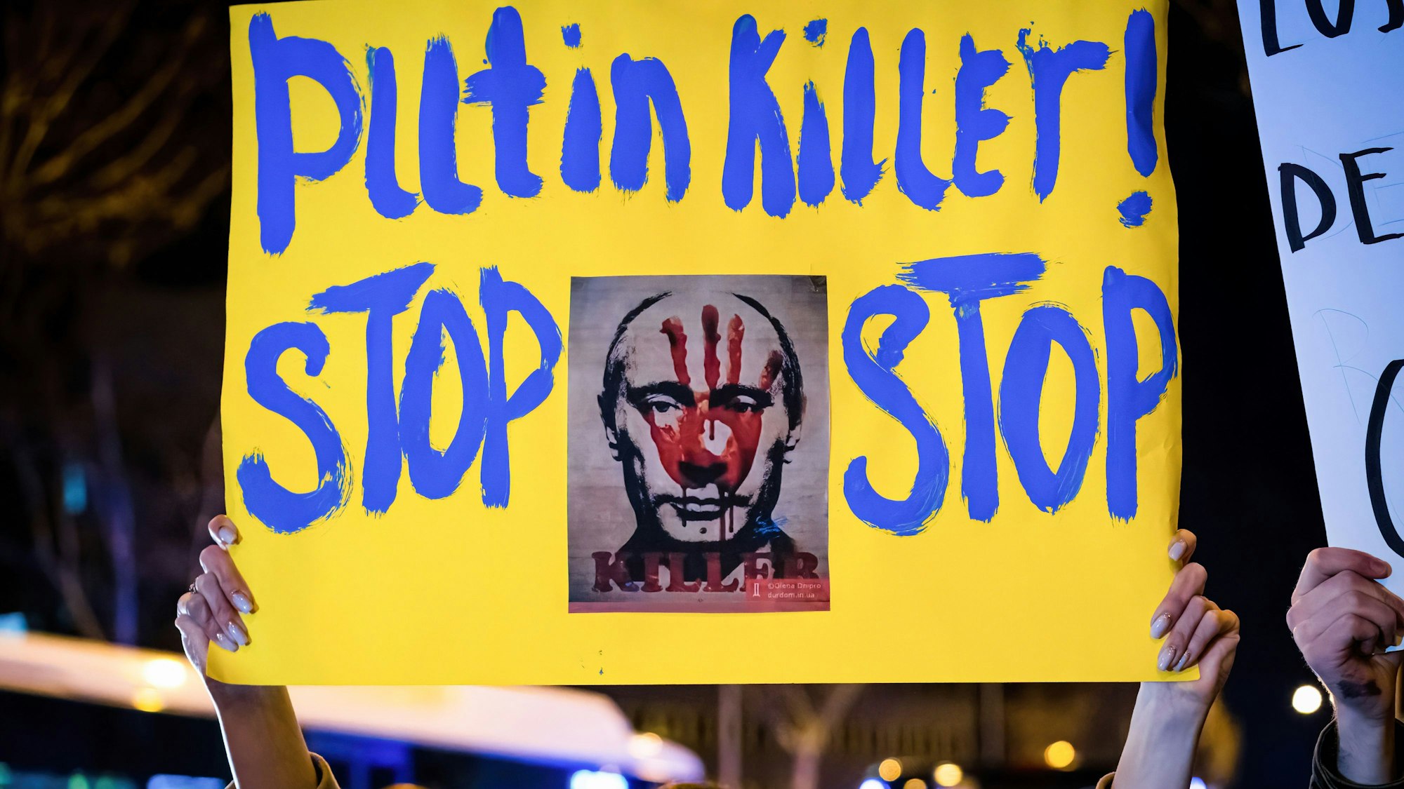 Ein Demonstrant hält ein Plakat mit der Aufschrift: „Putin Mörder! Stop Stop“ während einer Demonstration vor der russischen Botschaft in Madrid.