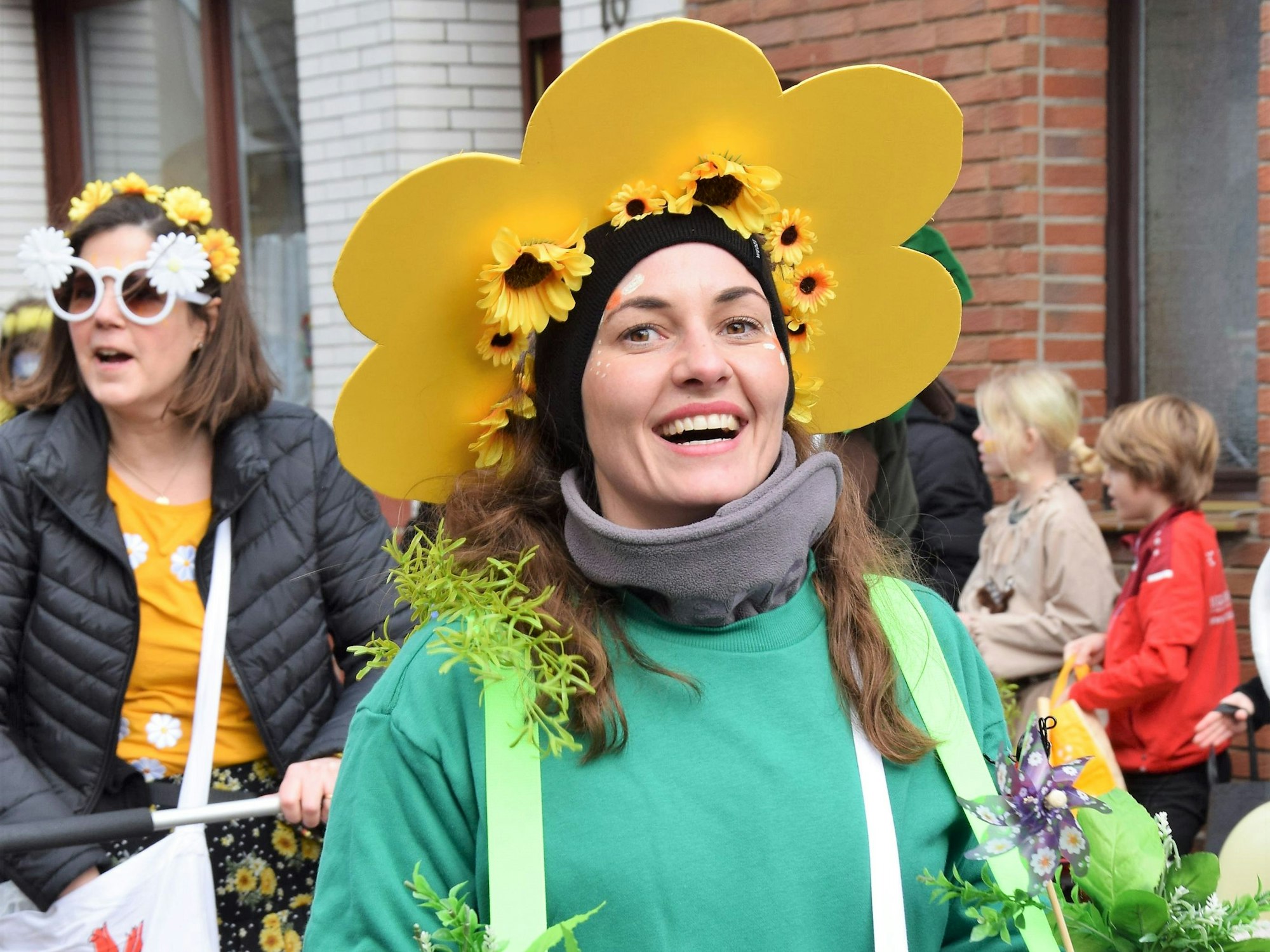 Eine Frau ist als Sonnenblume verkleidet und lacht in die Kamera.