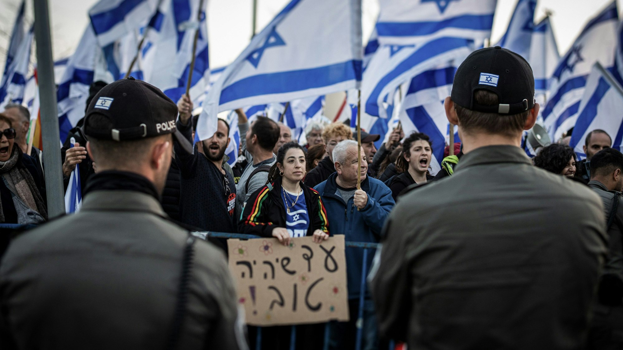 20.02.2023, Israel, Jerusalem: Demonstranten tragen israelische Fahnen während eines Protests