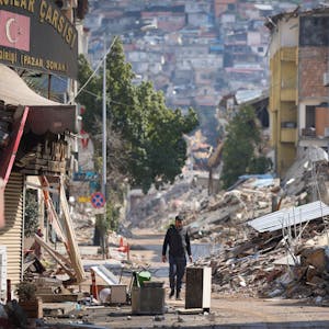 21.02.2023, Türkei, Antakya: Ein Mann geht an zerstörten Gebäuden entlang. Nach dem verheerenden Erdbeben am 06.02.2023 in der türkisch-syrischen Grenzregion kommt es immer wieder zu heftigen Nachbeben. Bei dem erneuten Erdbeben in der Südosttürkei ist die Zahl der Todesopfer weiter gestiegen. Foto: Unal Cam/AP/dpa +++ dpa-Bildfunk +++