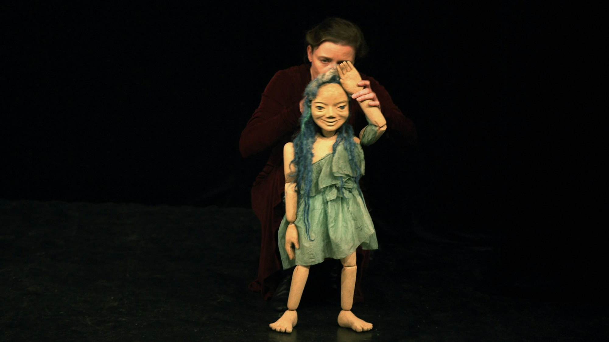 Eine Aufführung im Cassiopeia Theater in Köln, eine Schauspielerin mit einer Puppe.