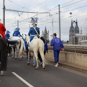 Funken reiten während des Rosenmontagszuges mit Pferden über die Deutzer Brücke.