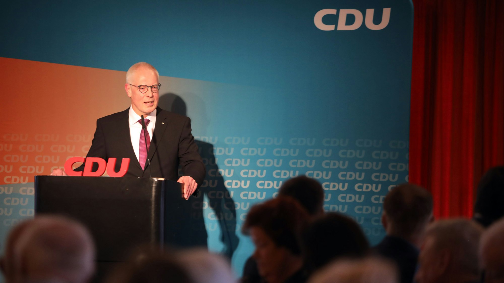Der CDU-Kreisvorsitzender Dr. Hermann-Josef Tebroke steht bei einer Versammlung an einem Rednerpult vor einer Wand mit CDU-Schriftzügen.