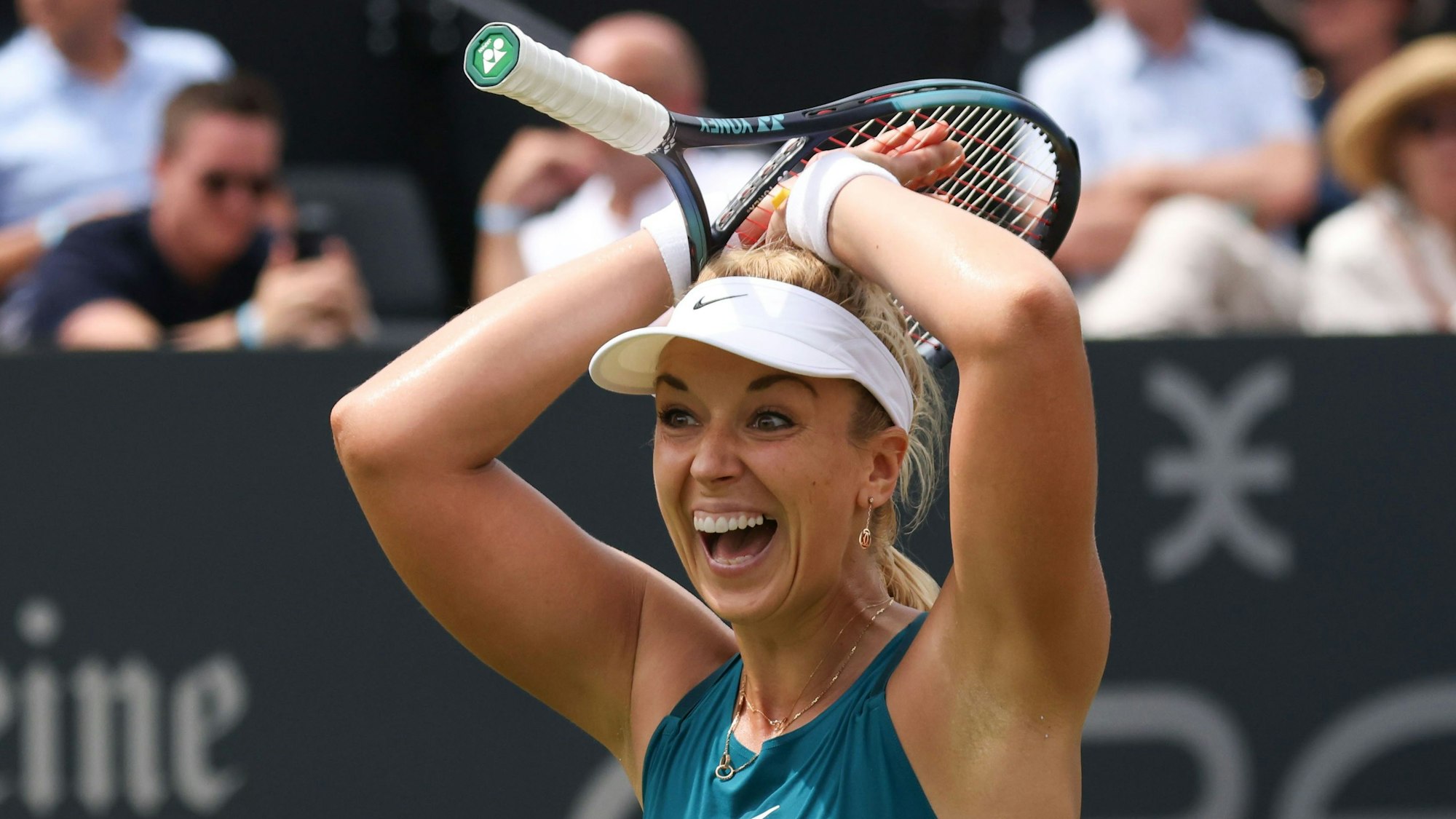 Sabine Lisicki lacht, trägt ein türkises Top, und streckt die Hände über den Kopf, dazwischen trägt sie einen Tennisschläger.