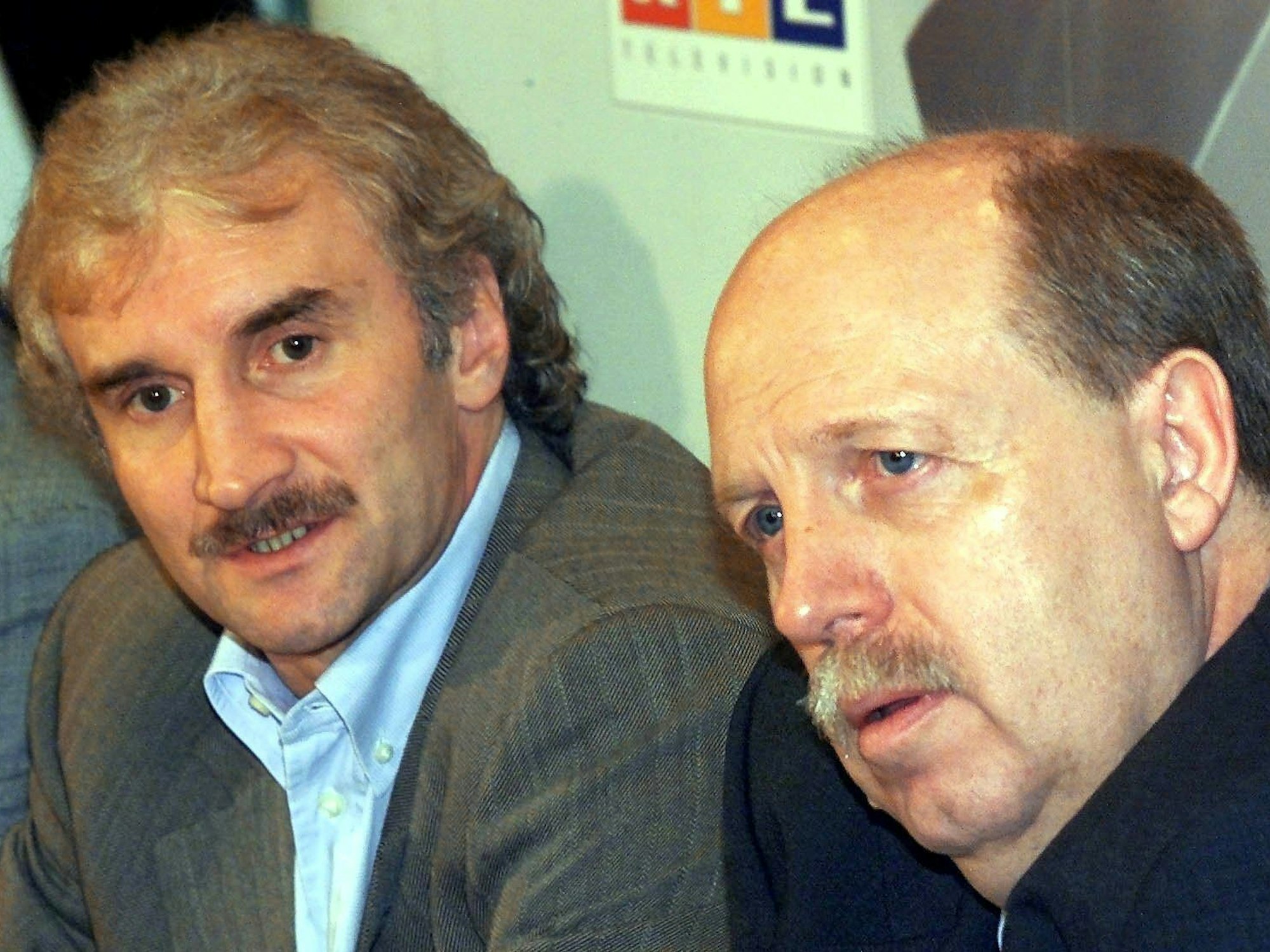 Reiner Calmund und Rudi Völler sitzen bei einer Pressekonferenz nebeneinander.
