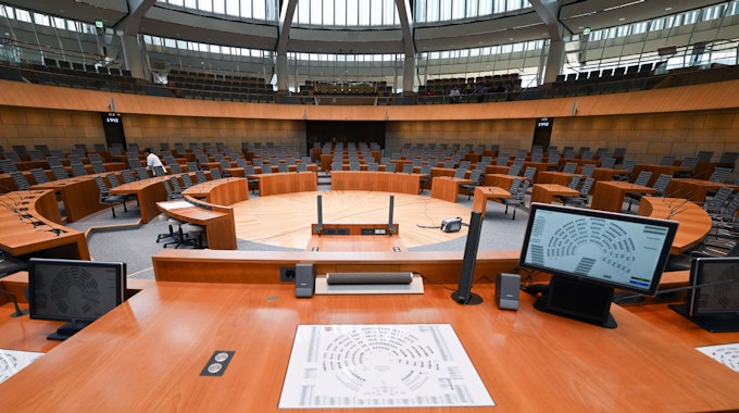 Zu sehen ist der Plenarsaal im nordrhein-westfälischen Landtag.Die Sitze sind leer, zentral steht ein Rednerpult.