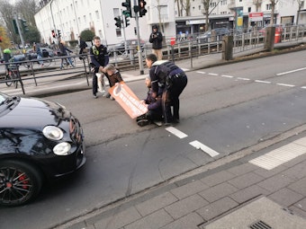 Bei einer Klima-Aktion in Köln war die Polizei sofort vor Ort und entfernte die Menschen von der Straße.