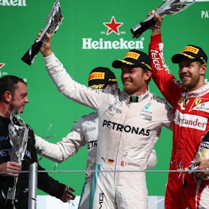 Nico Rosberg und Sebastian Vettel halten ihre Trophäen in die Höhe.
