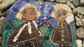 Auf einer gebrannten Keramikplatte sind vor einem grünen und blauen Hintergrund in Braun zwei Figuren dargestellt, ein Mann und eine Frau.