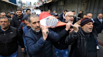 Trauernde Palästinenser tragen Todesopfer eines israelischen Angriffs auf einer Trage durch die Straßen.
