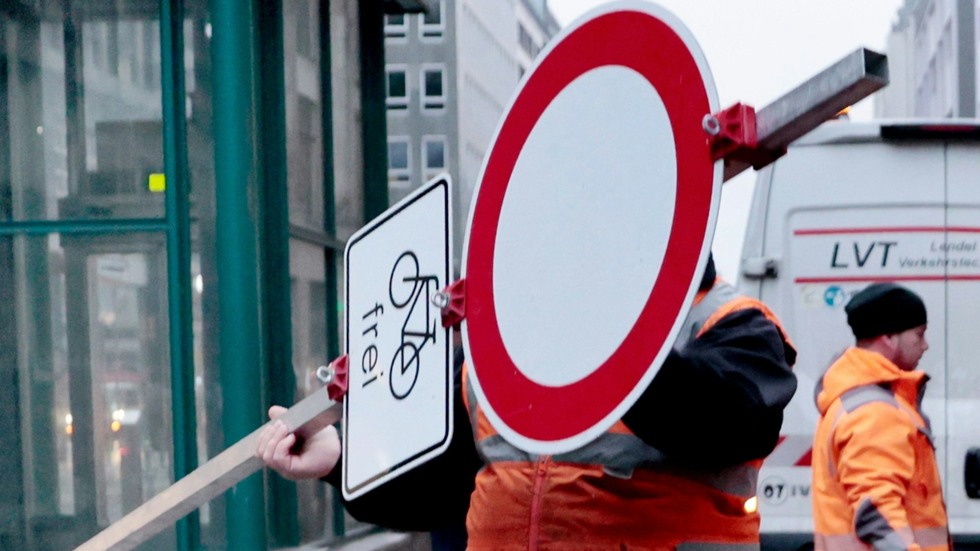 Ein Arbeiter stellt ein Durchfahrt-verboten-Schild auf.