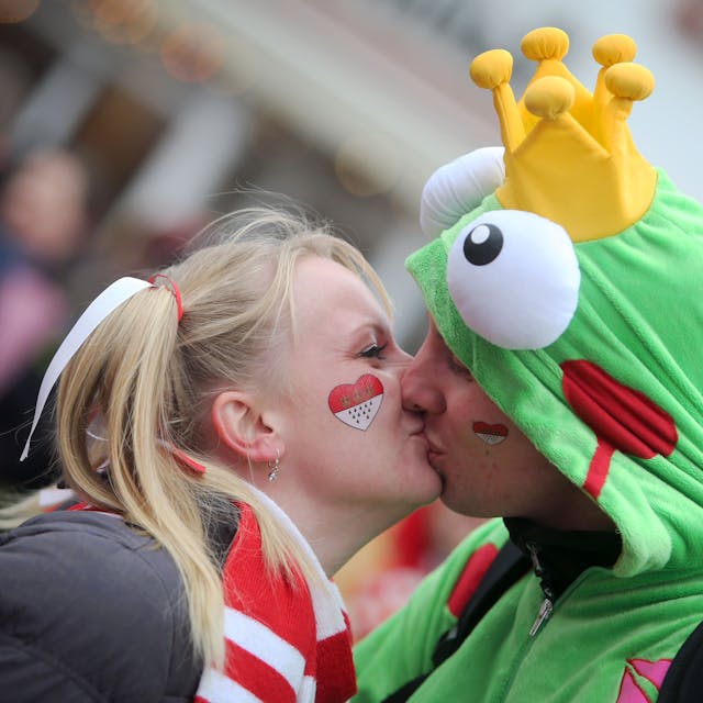 Eine Frau und ein Mann küssen sich in Karnevalskostümen.