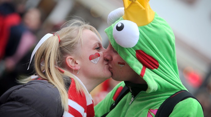 Eine Frau und ein Mann küssen sich in Karnevalskostümen.