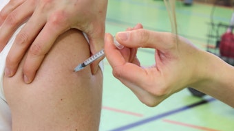 Ein Bürger lässt sich von einer medizinischen Mitarbeiterin den Impfstoff von Biontech gegen Corona in den Oberarm spritzen.