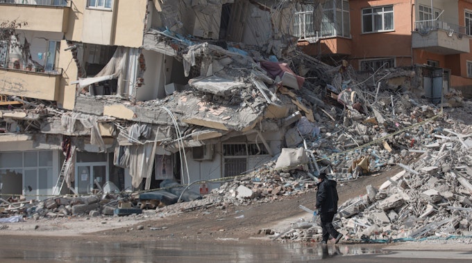 Türkei, Kharamanmaras: Ein Mann geht an einem eingestürzten Haus im Epizentrum des Erdbebens vorbei