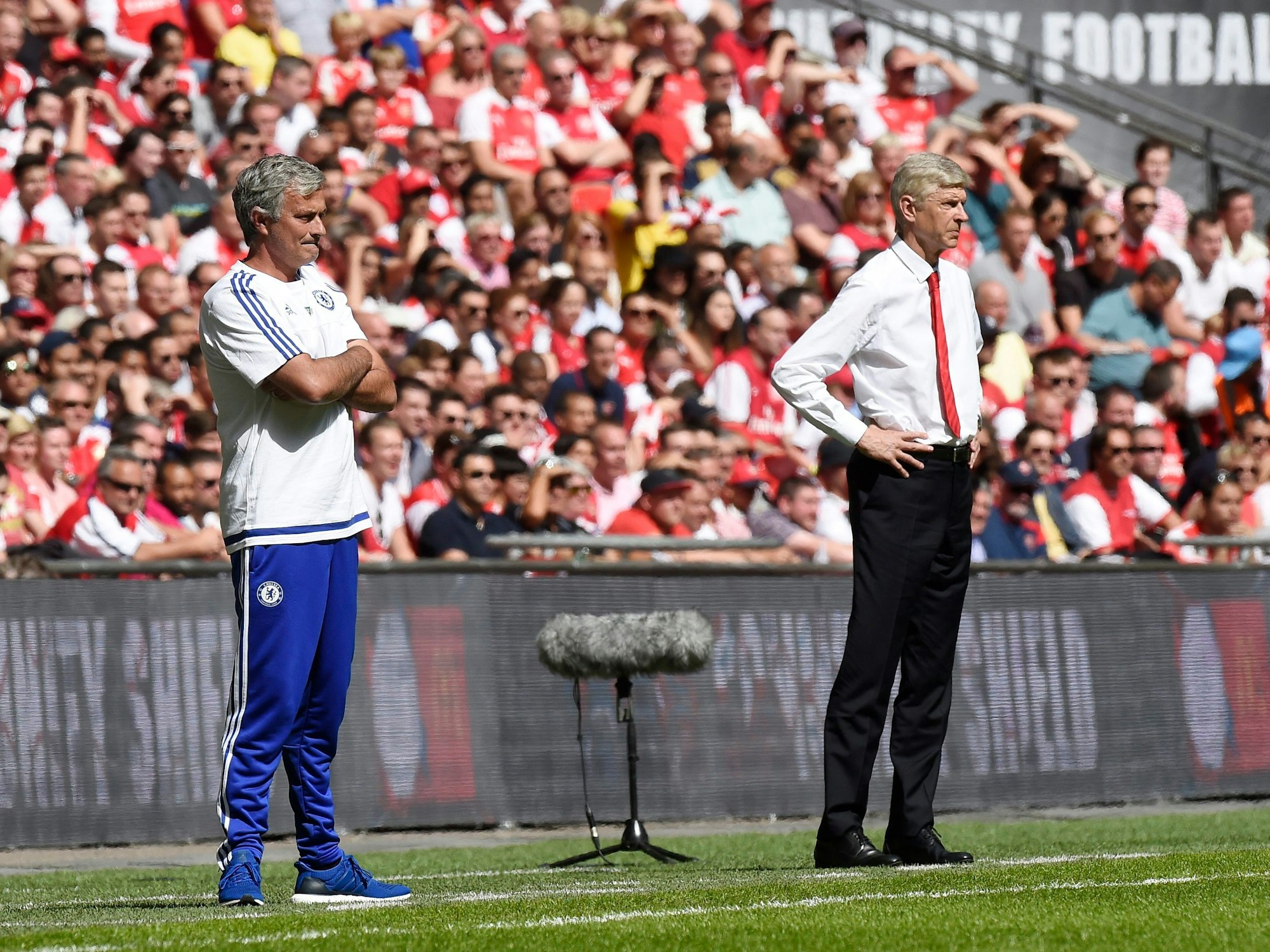 Mourinho und Wenger stehen am Spielfeldrand und beobachten das Spielgeschehen.