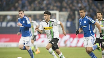 Mo Dahoud (M.) im Trikot von Borussia Mönchengladbach während des Bundesliga-Duells am 18. März 2016 bei Schalke 04. Aktuell steht der Mittelfeldspieler bei Borussia Dortmund unter Vertrag. Dahoud führt den Ball am Fuß. Er wird von einem Gegenspieler verfolgt.