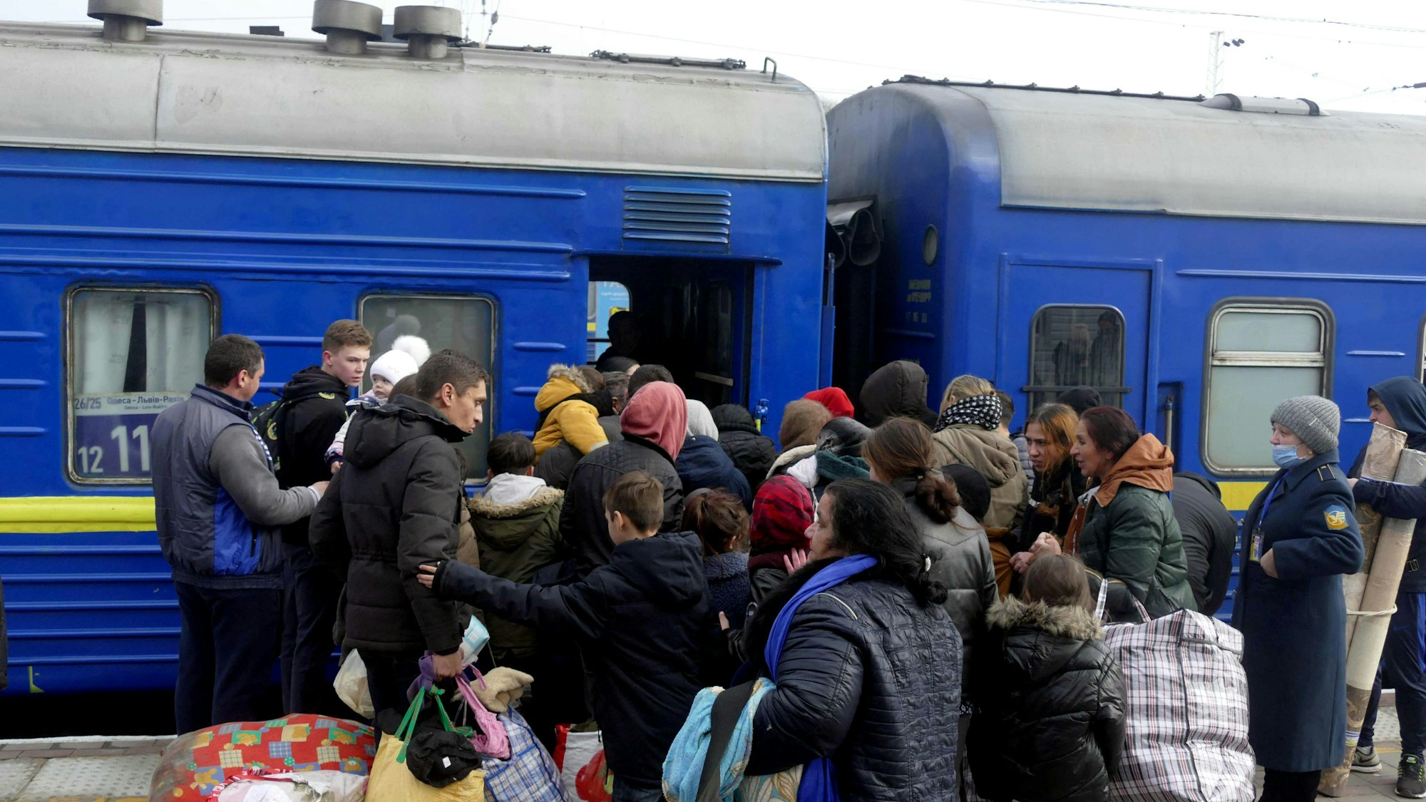 Menschen drängen sich am Bahnhof von Odesa in der Südukraine, um in den Evakuierungszug Odessa-Lviv-Rakhiv einzusteigen.