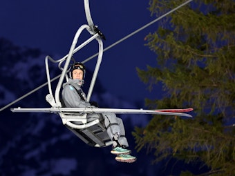 Andreas Wellinger (Deutschland) im Sessellift mit Skiern.