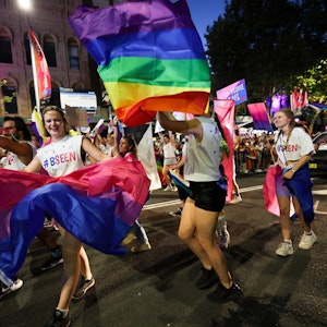 Menschen mit Regenbogenflaggen marschieren bei der 45. Mardi-Gras-Parade in Sydney mit.