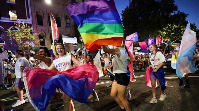 Menschen mit Regenbogenflaggen marschieren bei der 45. Mardi-Gras-Parade in Sydney mit.