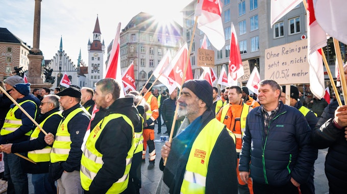 Menschen mit Verdi-Flaggen und Westen protestieren bei einem Streik für mehr Lohn.
