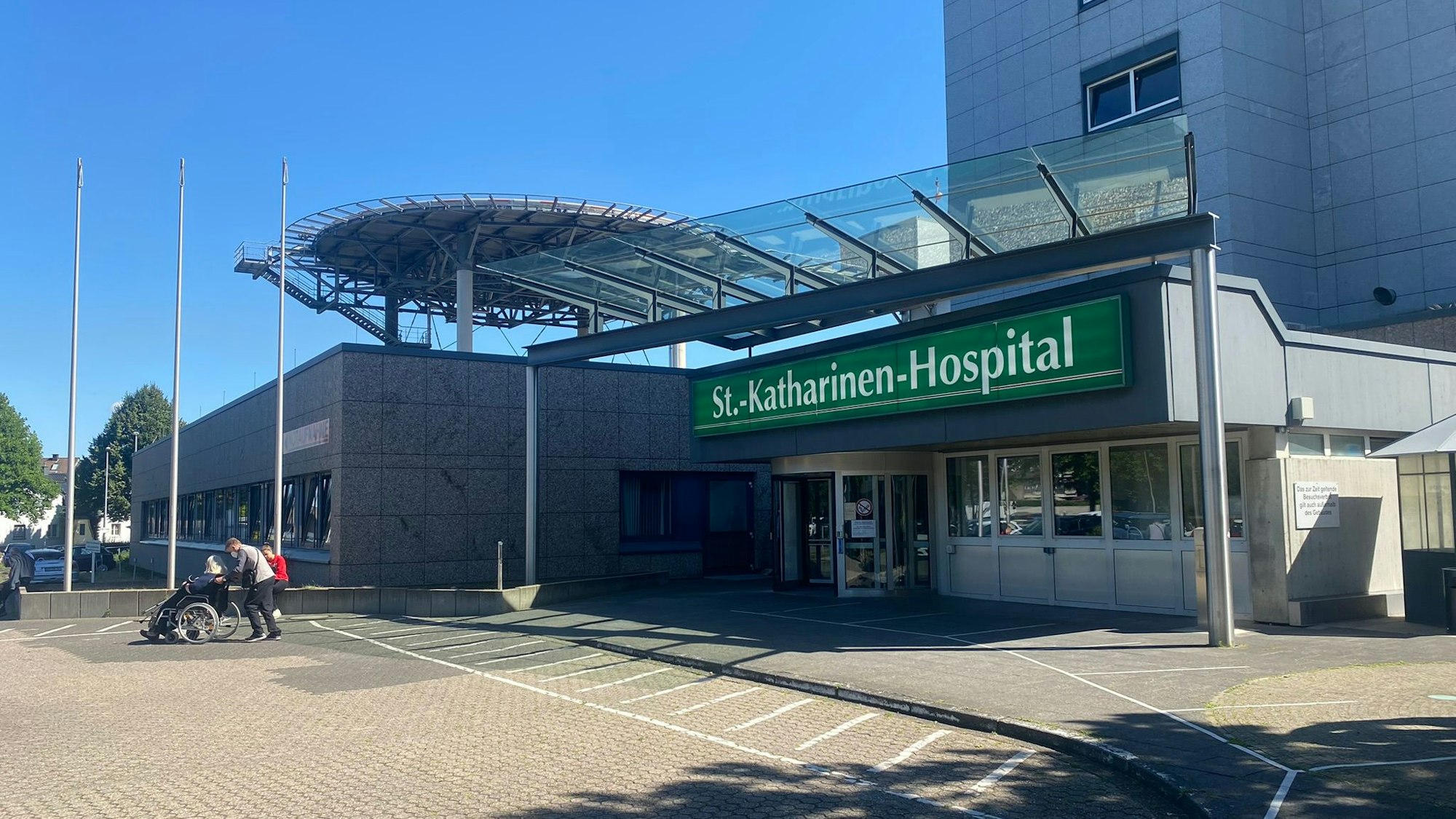 Das Foto zeigt den Eingangsbereich des Frechener Krankenhauses von außen. In weißer Schrift auf grünem Grund steht „St.-Katharina-Hospital“.