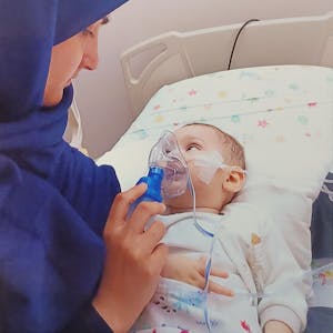 Nuran Atak hält am Bett ihres Kindes die Sauerstoffmaske, mit der der elf Monate alte Junge künstlich beatmet wird.