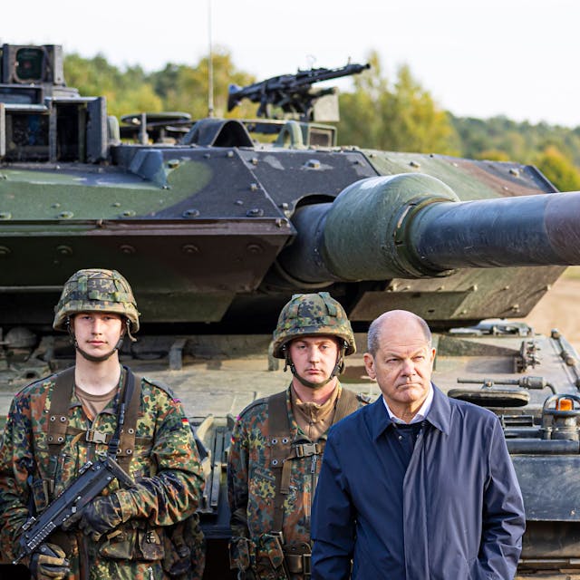 Bundeskanzler Olaf Scholz (SPD, 2.v.r) lässt sich vor der Ausbildungs- und Lehrübung des Heeres im Landkreis Heidekreis in der Lüneburger Heide den Kampfpanzer „Leopard 2“ der Bundeswehr erklären.