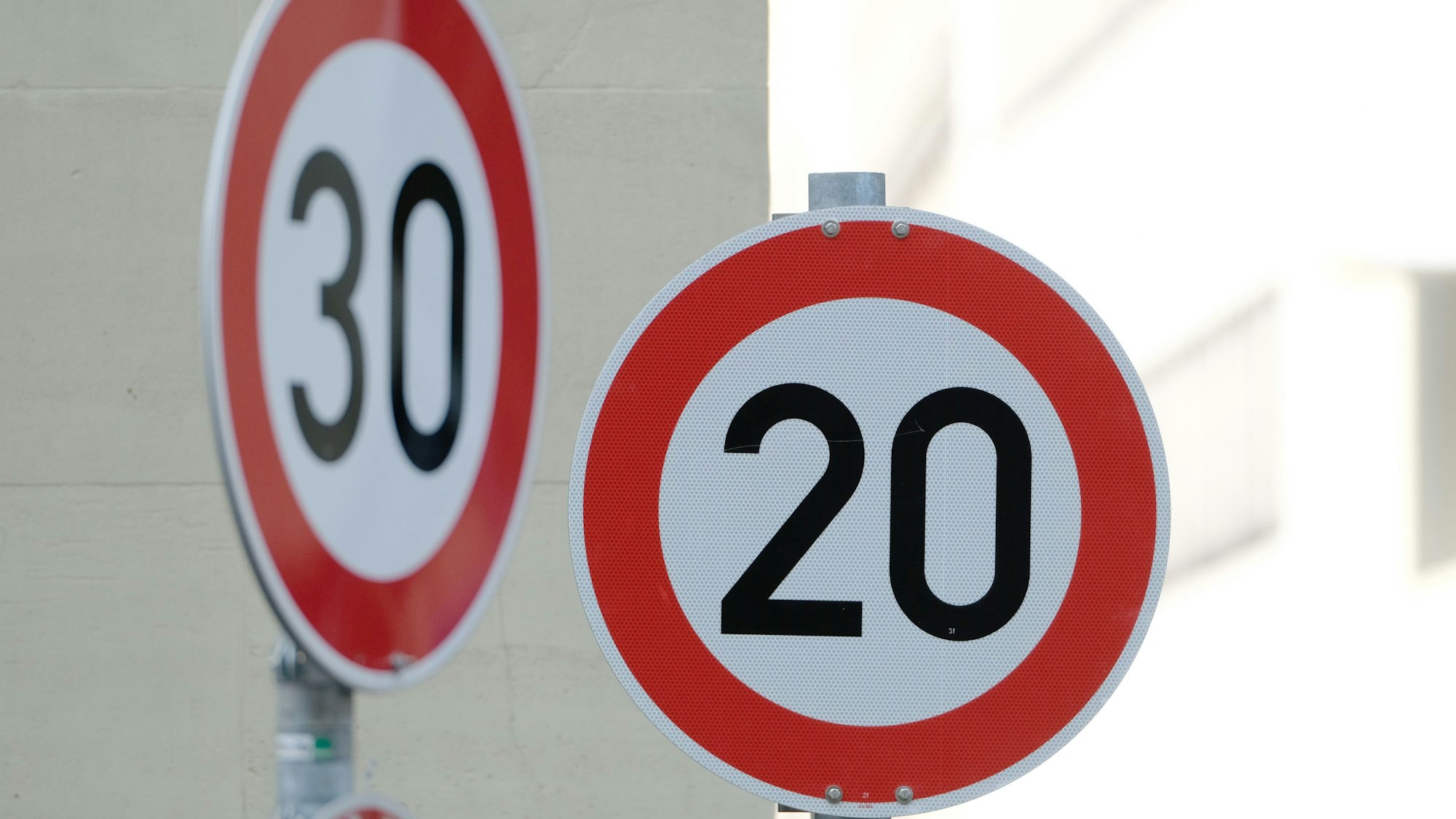 Straßenschilder mit dem Hinweis Tempo 20 und Tempo 30 sind in der Innenstadt an einer Kreuzung von zwei Straßen angebracht.