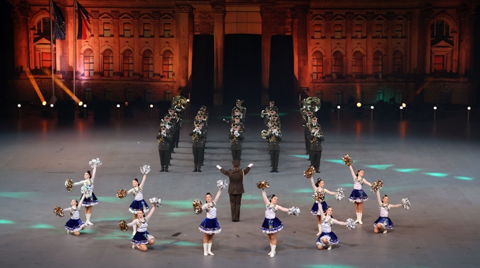 Vorne Tänzerinnen dahinter ein Militärorchester