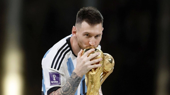 Lionel Messi küsst den WM-Pokal.