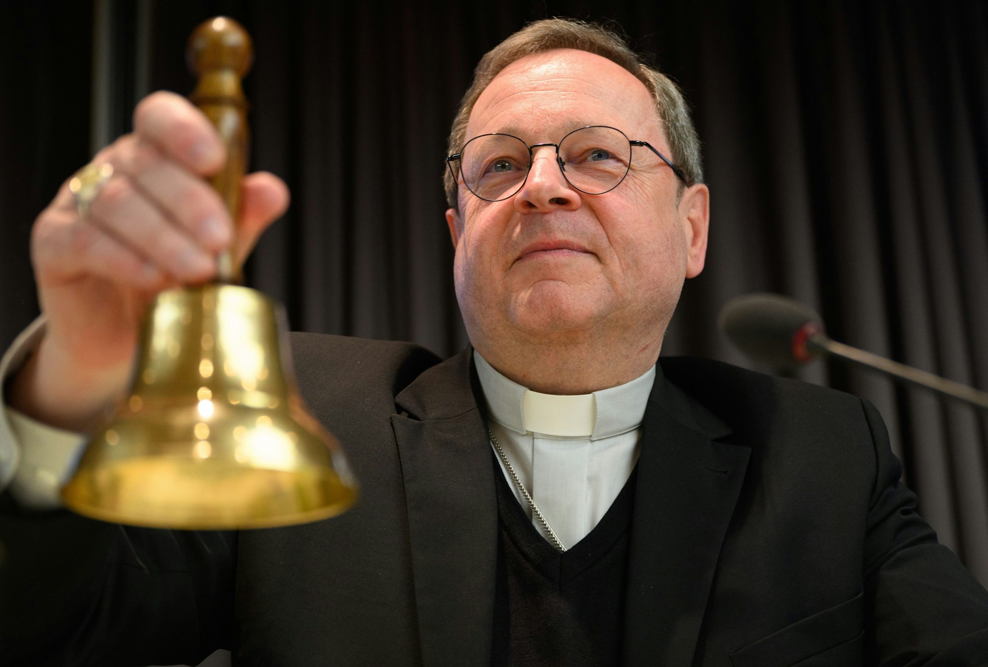 Georg Bätzing läutet vor Beginn der Frühjahrsvollversammlung der Deutschen Bischofskonferenz mit einer Glocke.