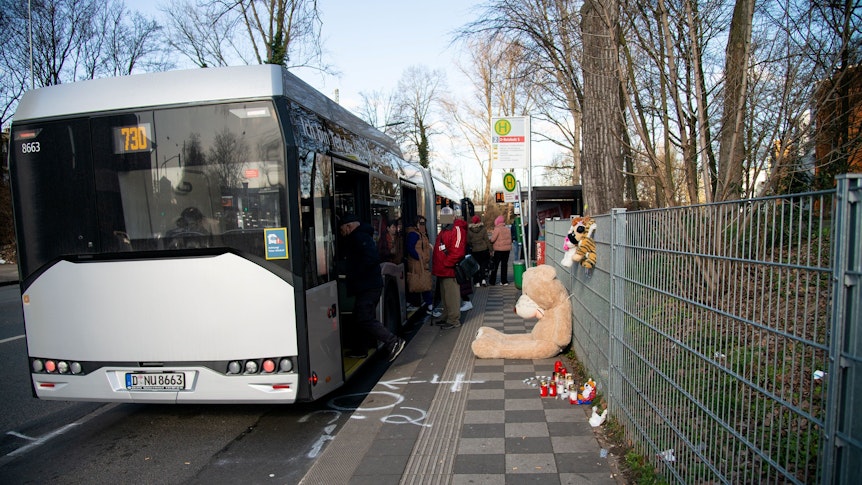Ein Bus hält an der Haltestelle, an der für den Verstorbenen Plüschtiere und Kerzen niedergelegt wurden.