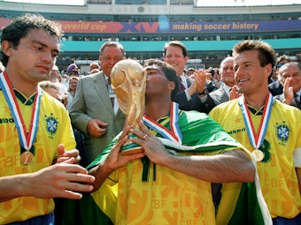 Romario küsst nach dem WM-Finale 1994 den Pokal, Branco und Dunga gucken zu.
