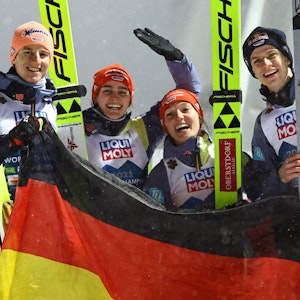 Karl Geiger, Selina Freitag, Katharina Althaus, Andreas Wellinger aus Deutschland jubeln nach Gold im Mixed-Wettbewerb.