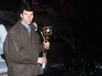 Marco van Basten posiert mit seiner Weltfußballer-Trophäe.