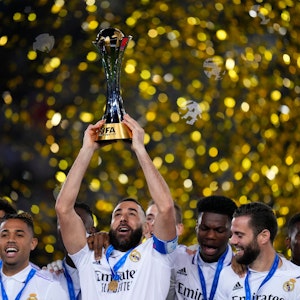 Karim Benzema (M) von Real Madrid hält den Pokal hoch, als er mit seinen Mannschaftskameraden nach dem Sieg feiert.