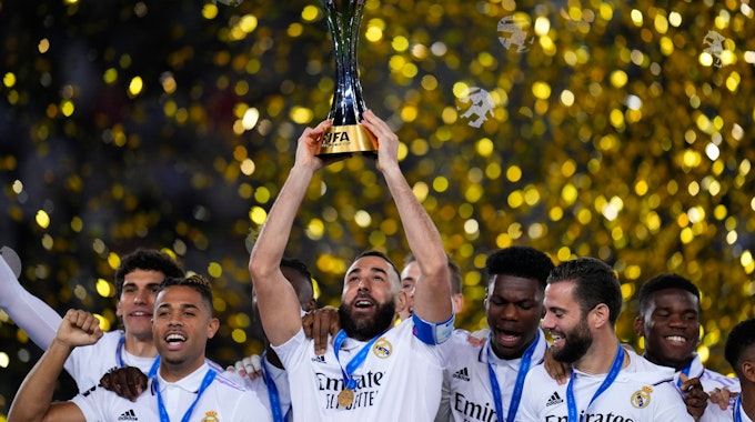 Karim Benzema (M) von Real Madrid hält den Pokal hoch, als er mit seinen Mannschaftskameraden nach dem Sieg feiert.