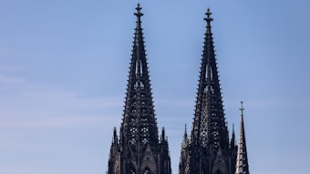 Die beiden Türme des Kölner Dom (Hohe Domkirche St. Petrus) sind vor einem blauen Himmel zu sehen.