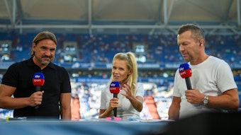 Daniel Farke (l.) und Lothar Matthäus (r.) hören vor dem Bundesliga-Spiel von Borussia Mönchengladbach beim FC Schalke 04 am 13. August 2022 der Analyse von Julia Simic bei einer Sky-Übertragung zu. Alle halten ein Mikrofon des Pay-TV-Senders in der Hand.