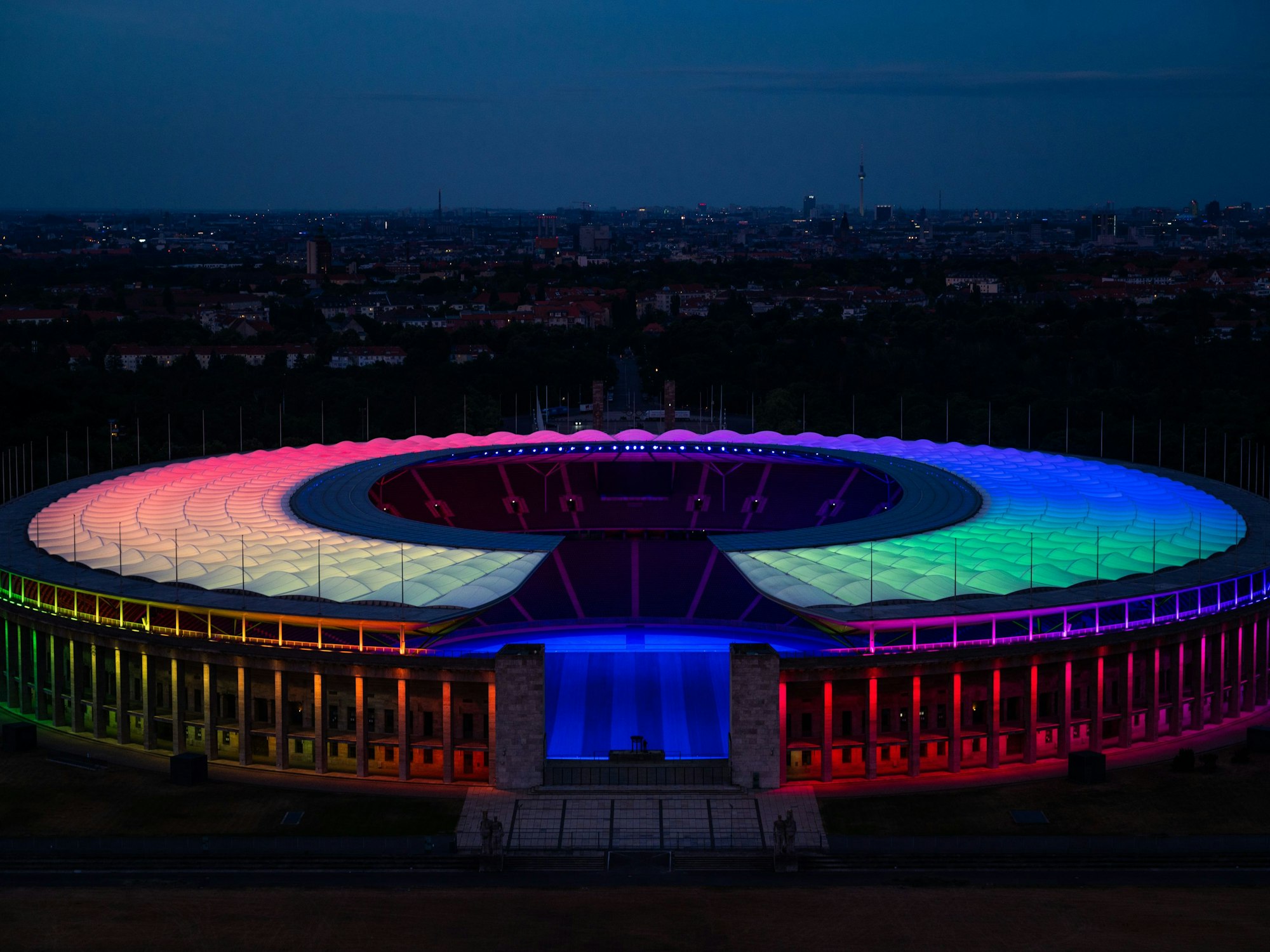 Das Olympiastadion in Berlin ist von oben zu sehen und ist während des Spiels in Regenbogenfarben beleuchtet. 