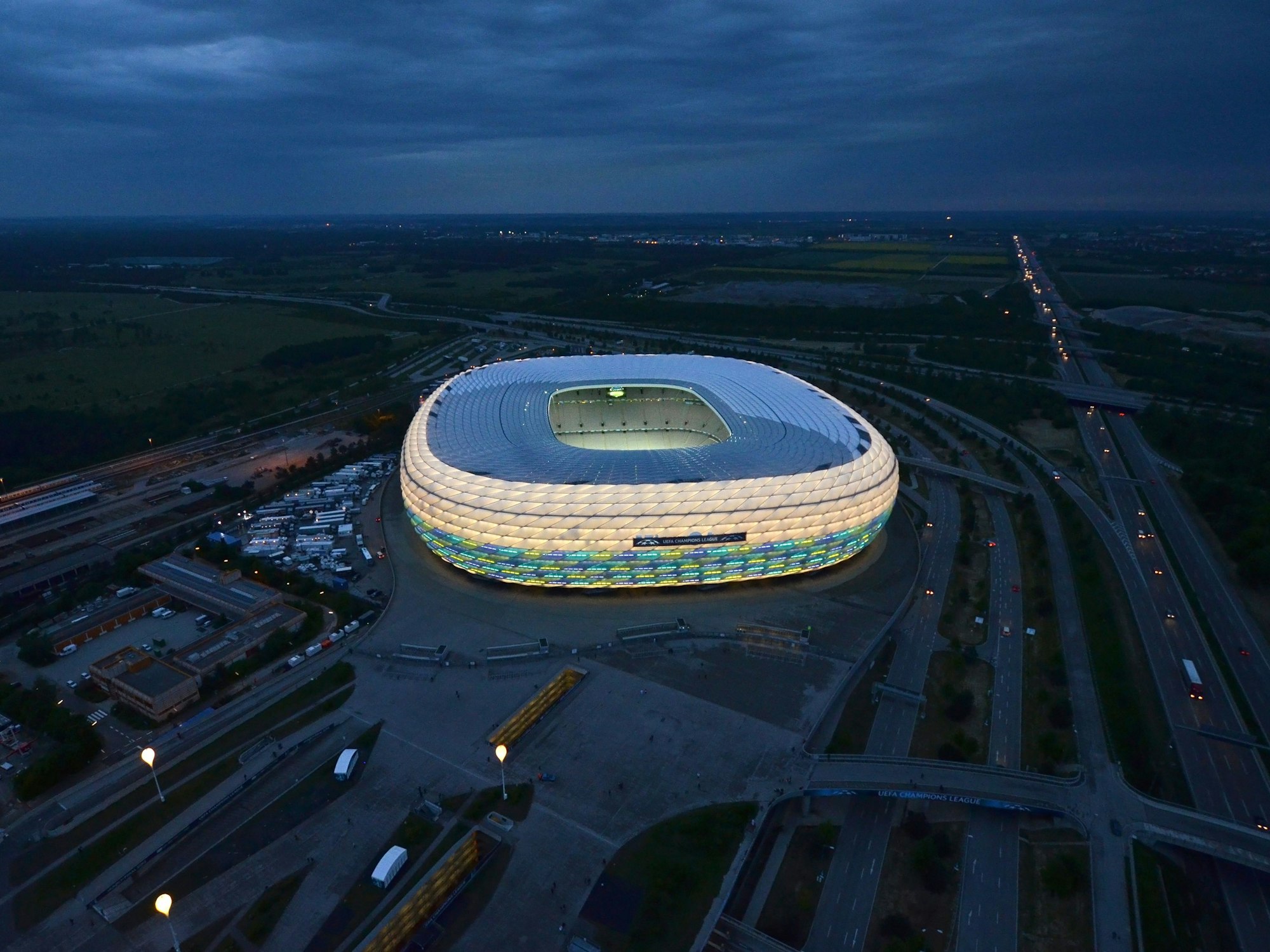 Die Allianz Arena ist von oben zu sehen und erstrahlt in verschiedenen Farben. 