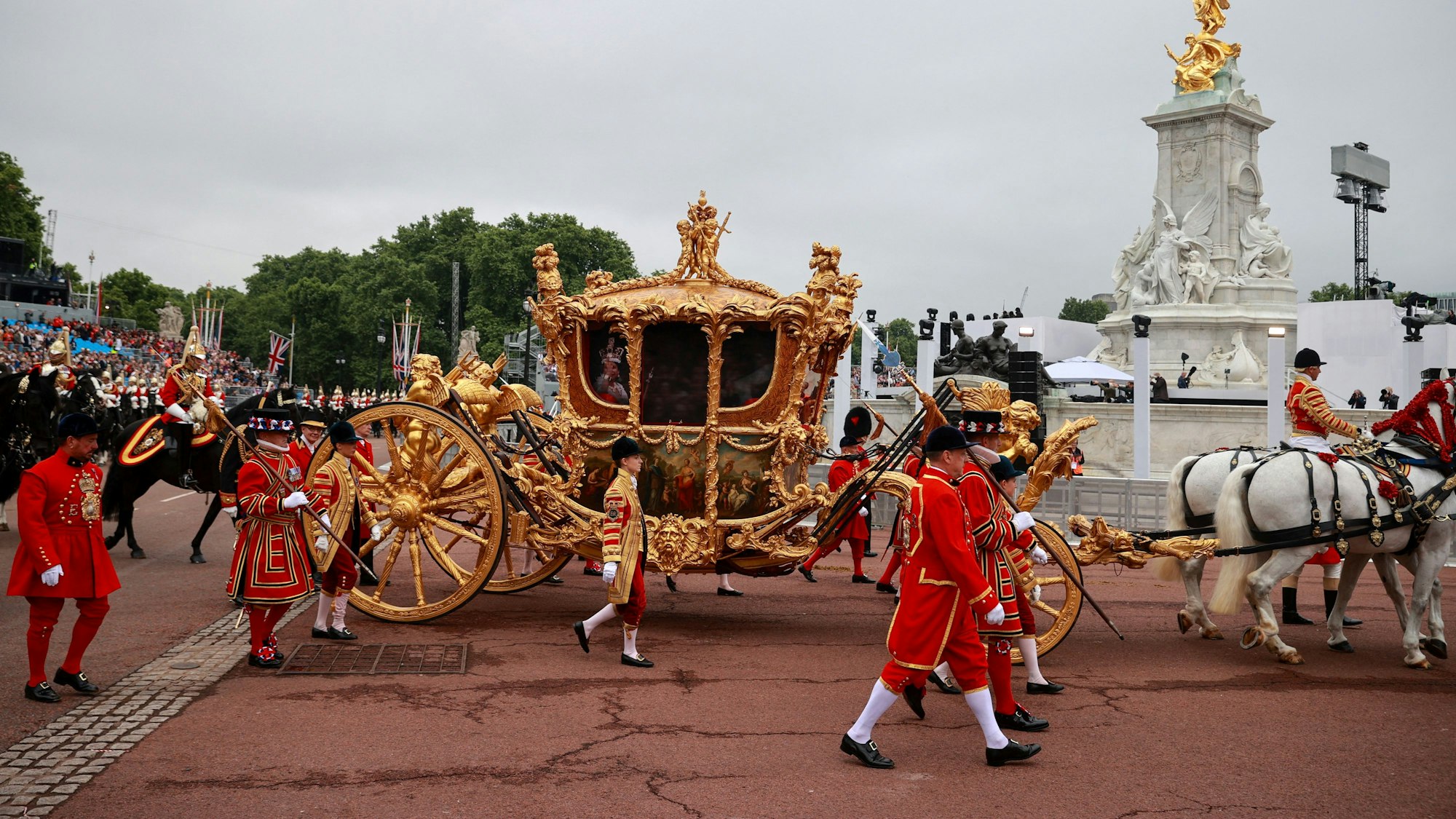 Die goldene Staatskutsche fährt während eines Festumzuges am vierten Tag der Feierlichkeiten zum Platinjubiläum der Queen vor dem Buckingham Palace vorbei. Der Festumzug ist ein Karnevalsumzug auf der Mall mit riesigen Puppen und Prominenten, die Schlüsselmomente aus den sieben Jahrzehnten der Thronbesteigung von Königin Elizabeth II. darstellen. +++ dpa-Bildfunk +++
