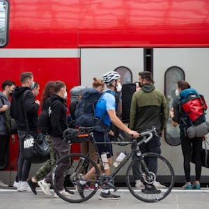 Fahrgäste steigen am Kölner Hauptbahnhof in einen Zug ein. (Archivbild)