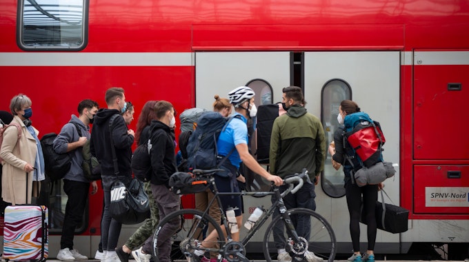 Fahrgäste steigen am Kölner Hauptbahnhof in einen Zug ein. (Archivbild)